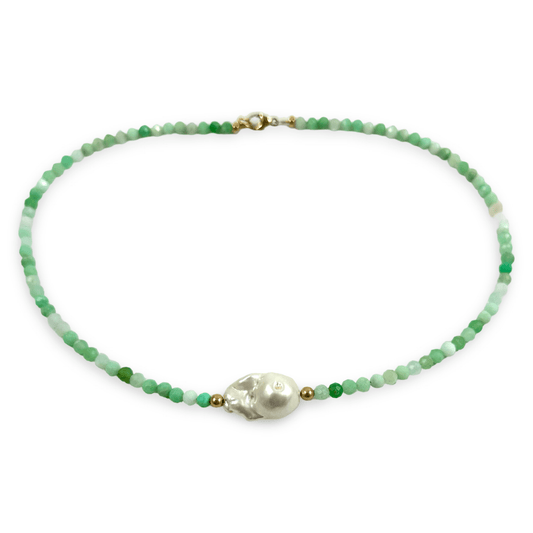 A beaded necklace featuring faceted green and white beads, a central white baroque pearl, and small gold spacer beads, displayed on a clean white background.