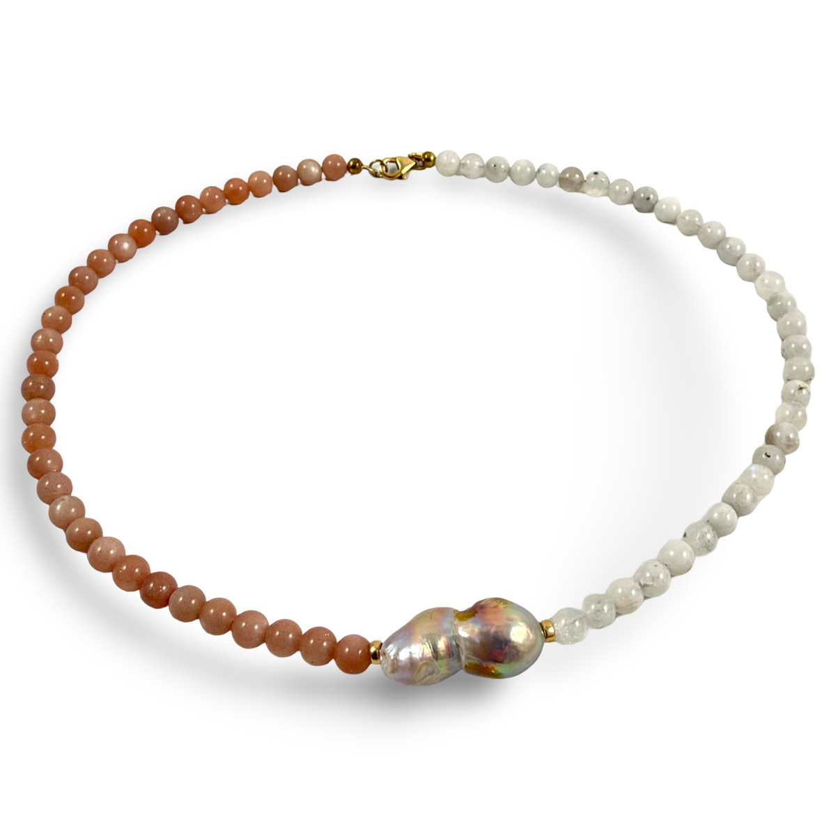 A beaded necklace featuring two distinct strands: one made of smooth, warm brown beads and the other of small, textured white beads, joined by a large, irregular baroque pearl and a small gold clasp.