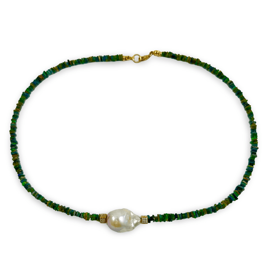 A beaded necklace featuring small green and blue faceted beads with a single large, irregular white baroque pearl at the center, accented by small gold spacer beads and a gold clasp, shown on a plain white background.