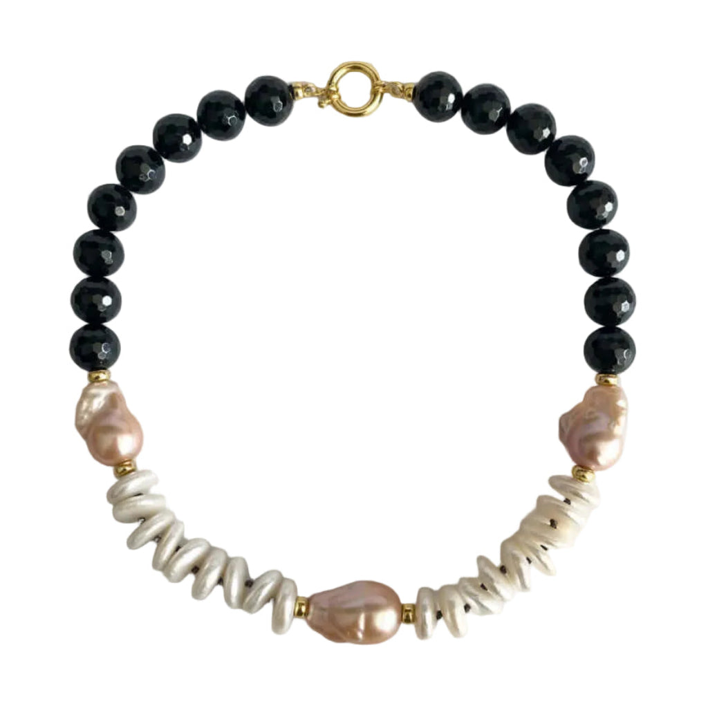 A beaded necklace featuring faceted black beads, irregular white shell beads, and natural pink baroque pearls, accented with small gold spacers and a gold clasp, displayed on a clean white background.