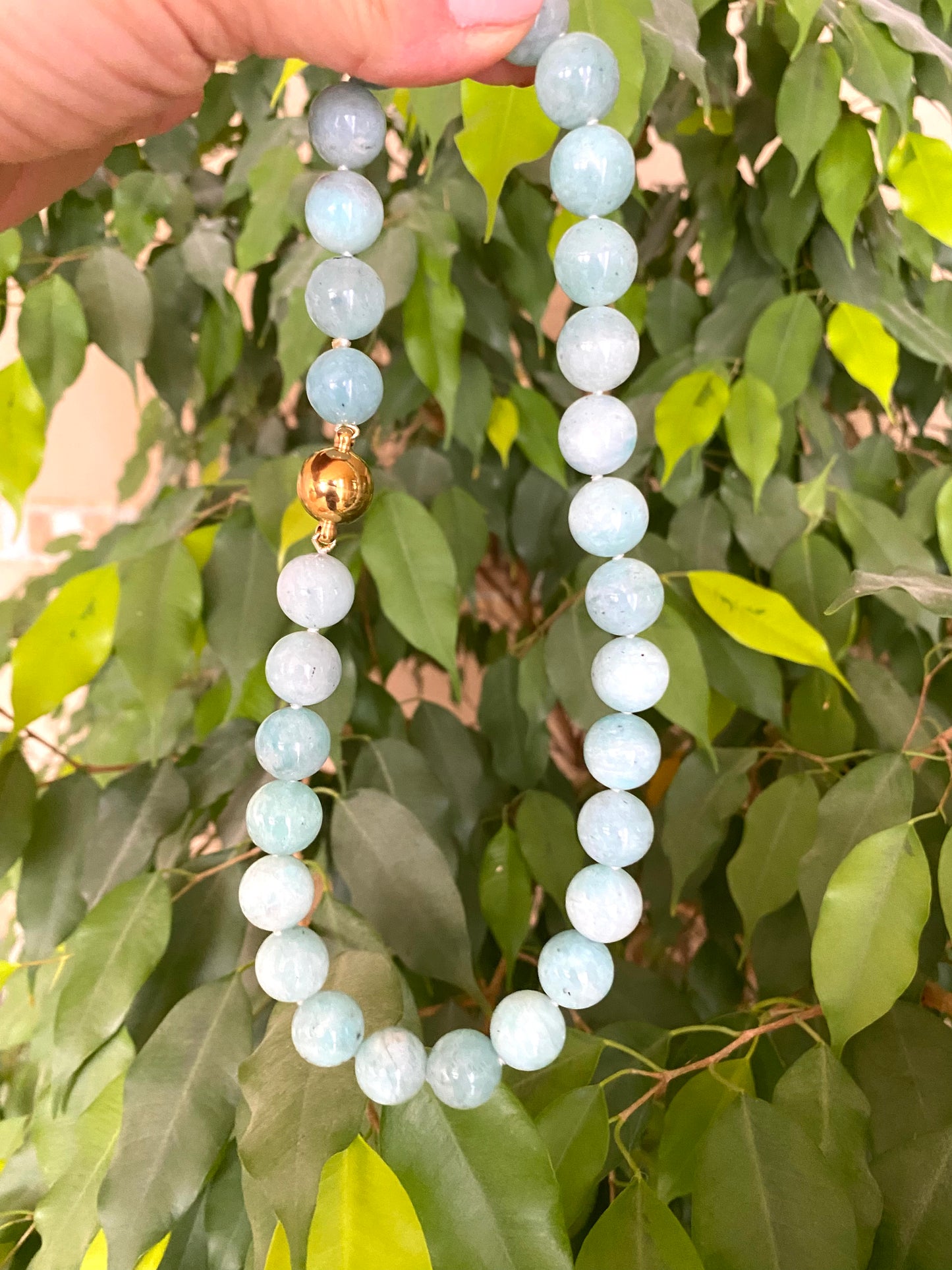 holding a hand knotted amazonite necklace