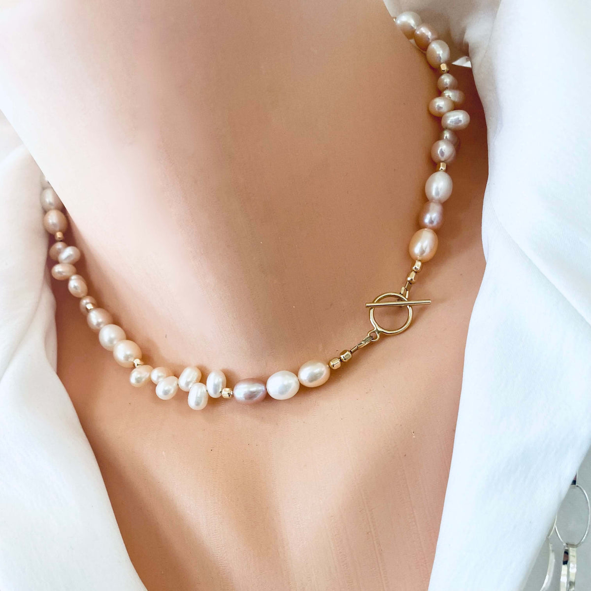Pearl toggle necklace with pastel pearls and 14K gold filled clasp worn on a mannequin's neck.