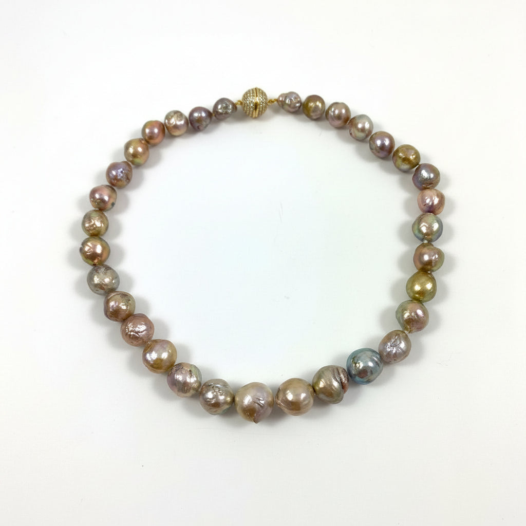 A beaded strand bracelet made of irregular, iridescent baroque pearls in shades of bronze, gold, brown, and muted purple, with a small gold clasp, shown on a plain white background.