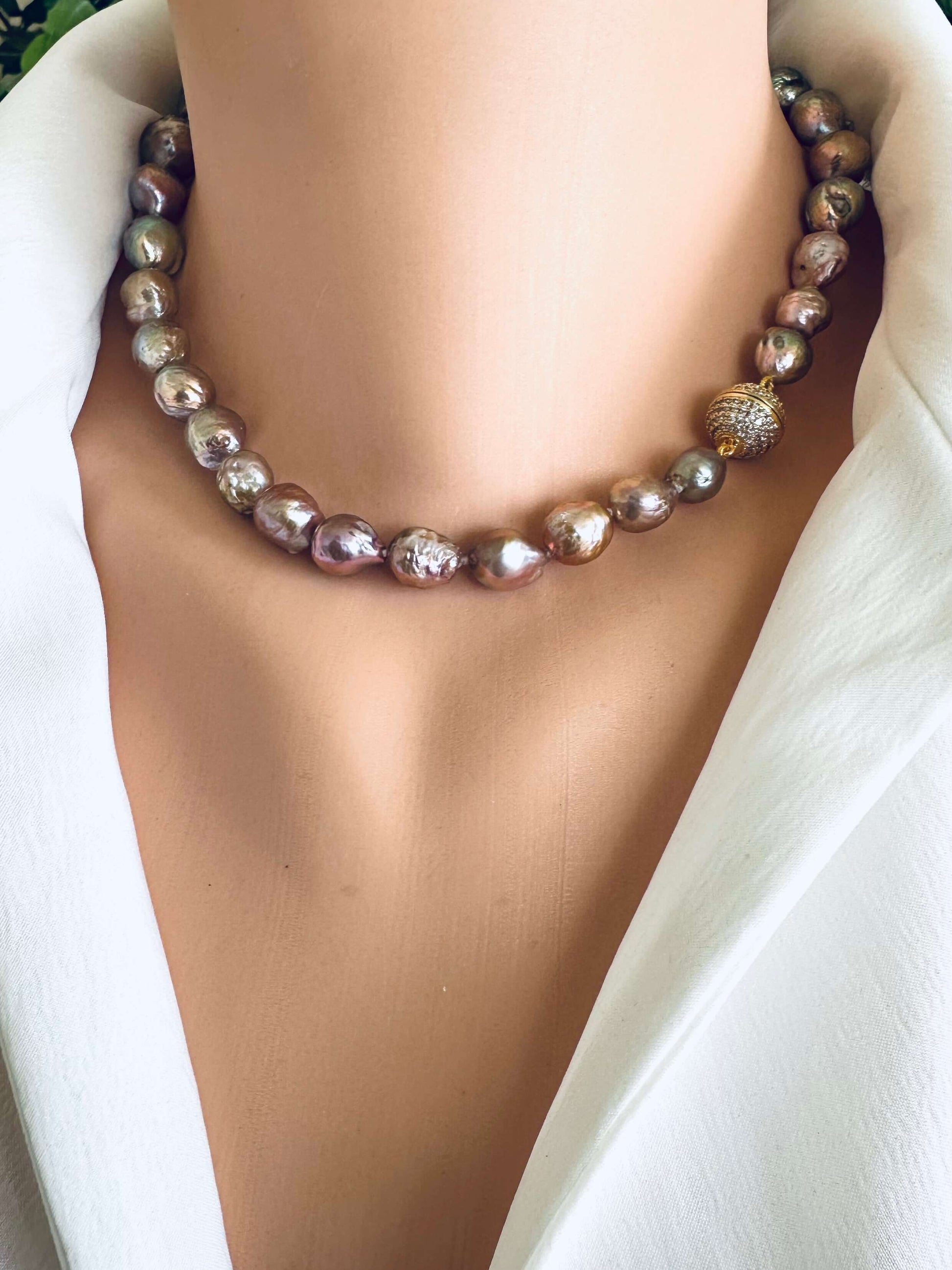 Necklace with pink metallic lustre pearls on a white background