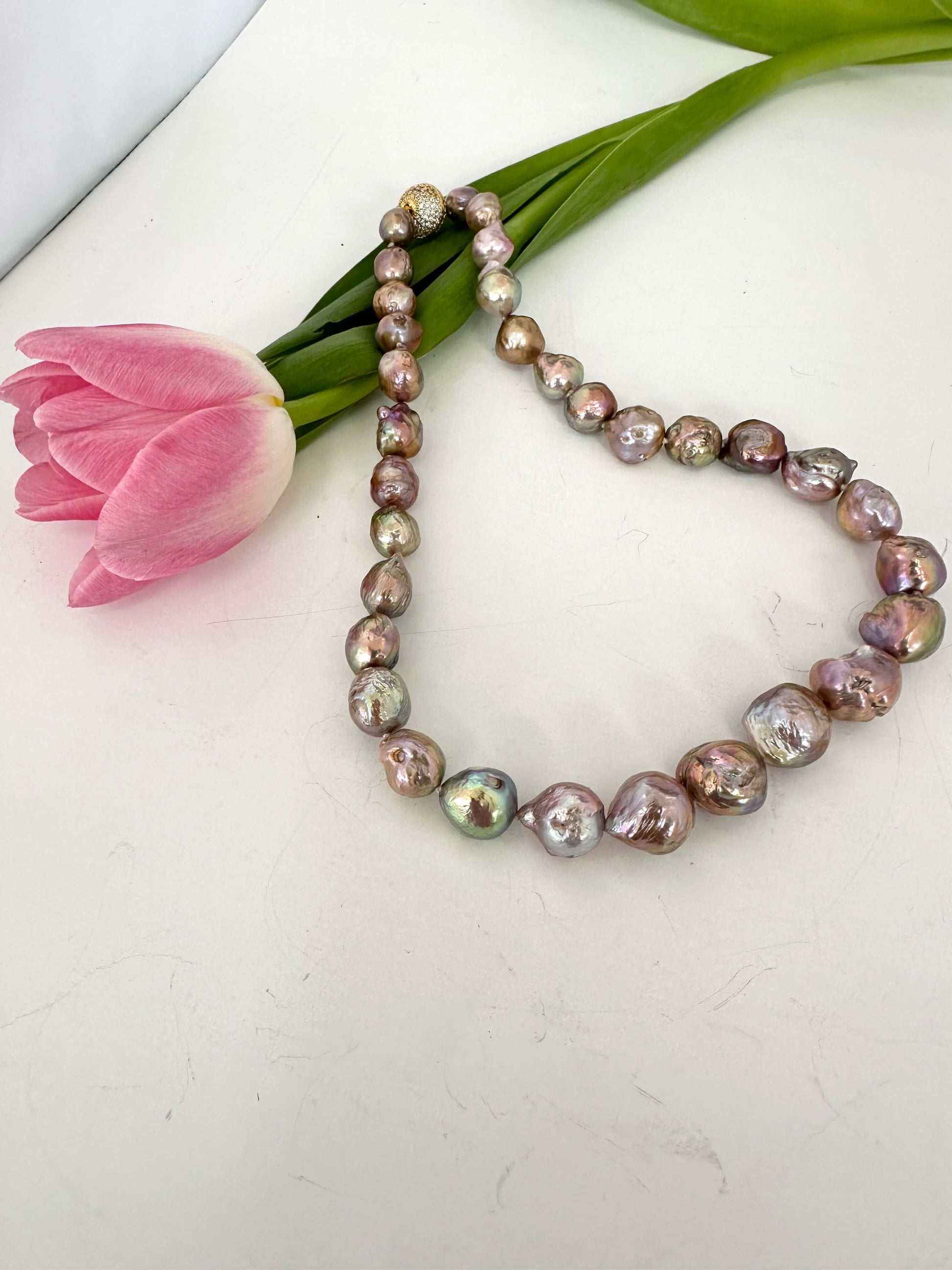 Pearl necklace with a pink tulip on a white background