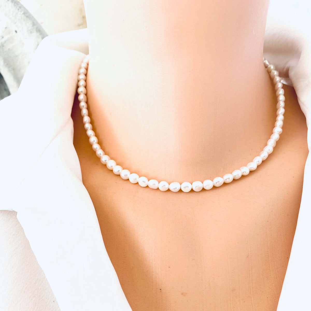Classic White Pearl Necklace without charm shown in frontal close-up on mannequin for detail.