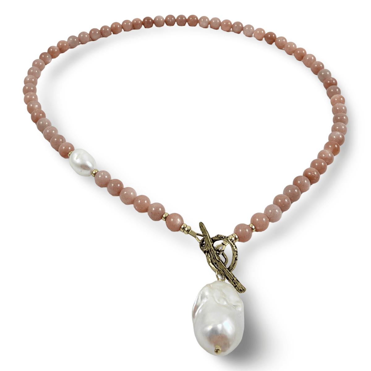 A beaded necklace featuring dusty rose quartz beads, a single white pearl spacer, and a large baroque pearl pendant suspended from an antique bronze toggle clasp, shown on a clean white background.