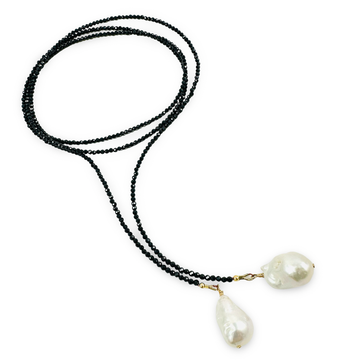 A long-strand necklace featuring a black beaded chain and two large, irregular white baroque pearls suspended from gold-toned clasps, displayed on a clean white background.