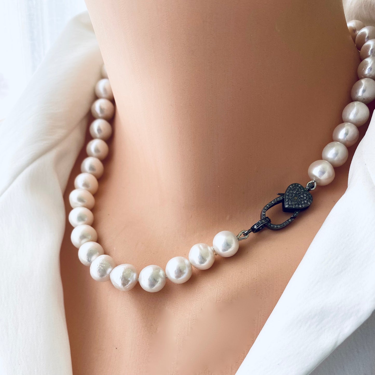 Edison pearl necklace featuring graduated white pearls and a heart pavé diamond clasp, showcasing luxury and elegance.