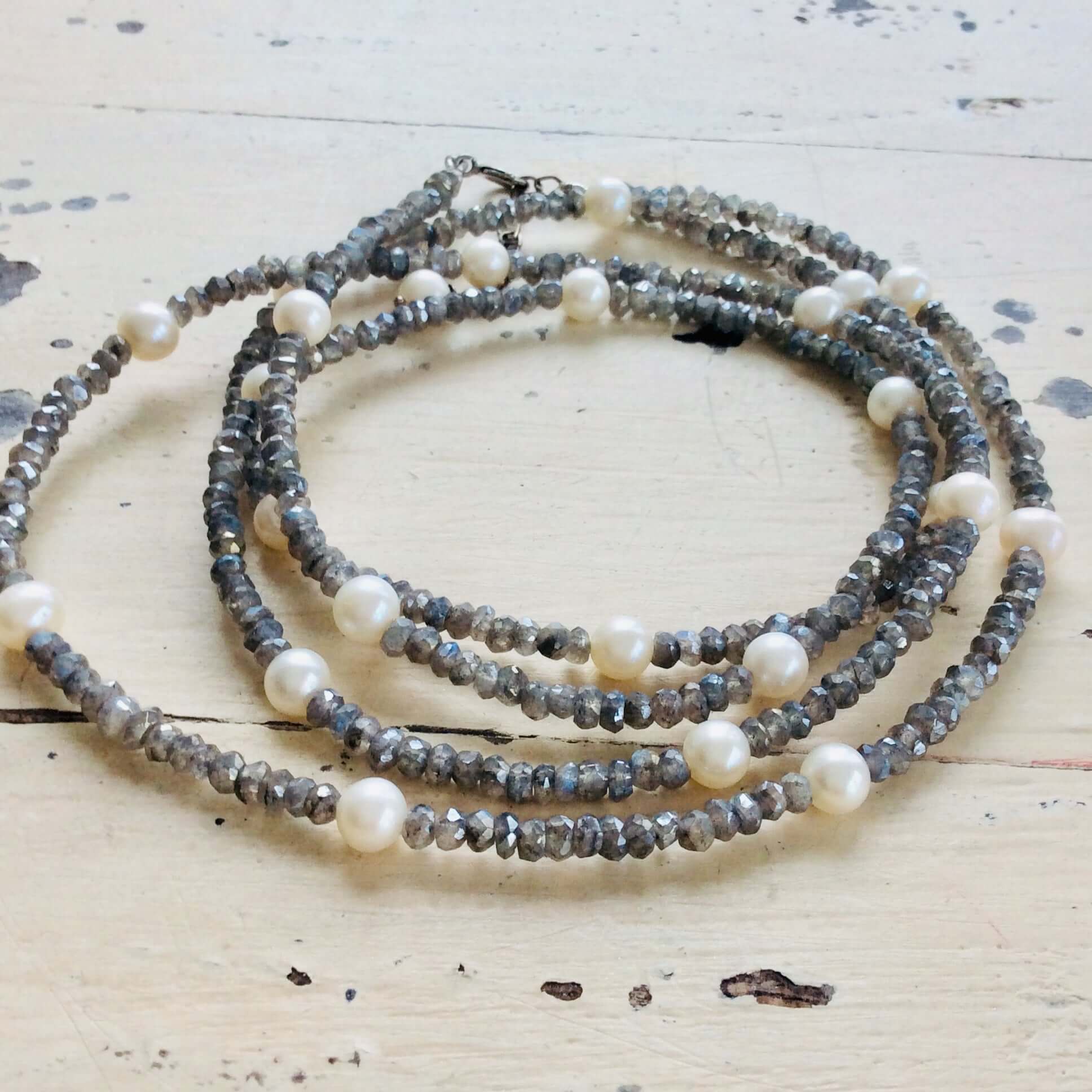 Labradorite pearl necklace 40 inches featuring grey iridescent gemstones and white freshwater pearls on rustic wooden background.