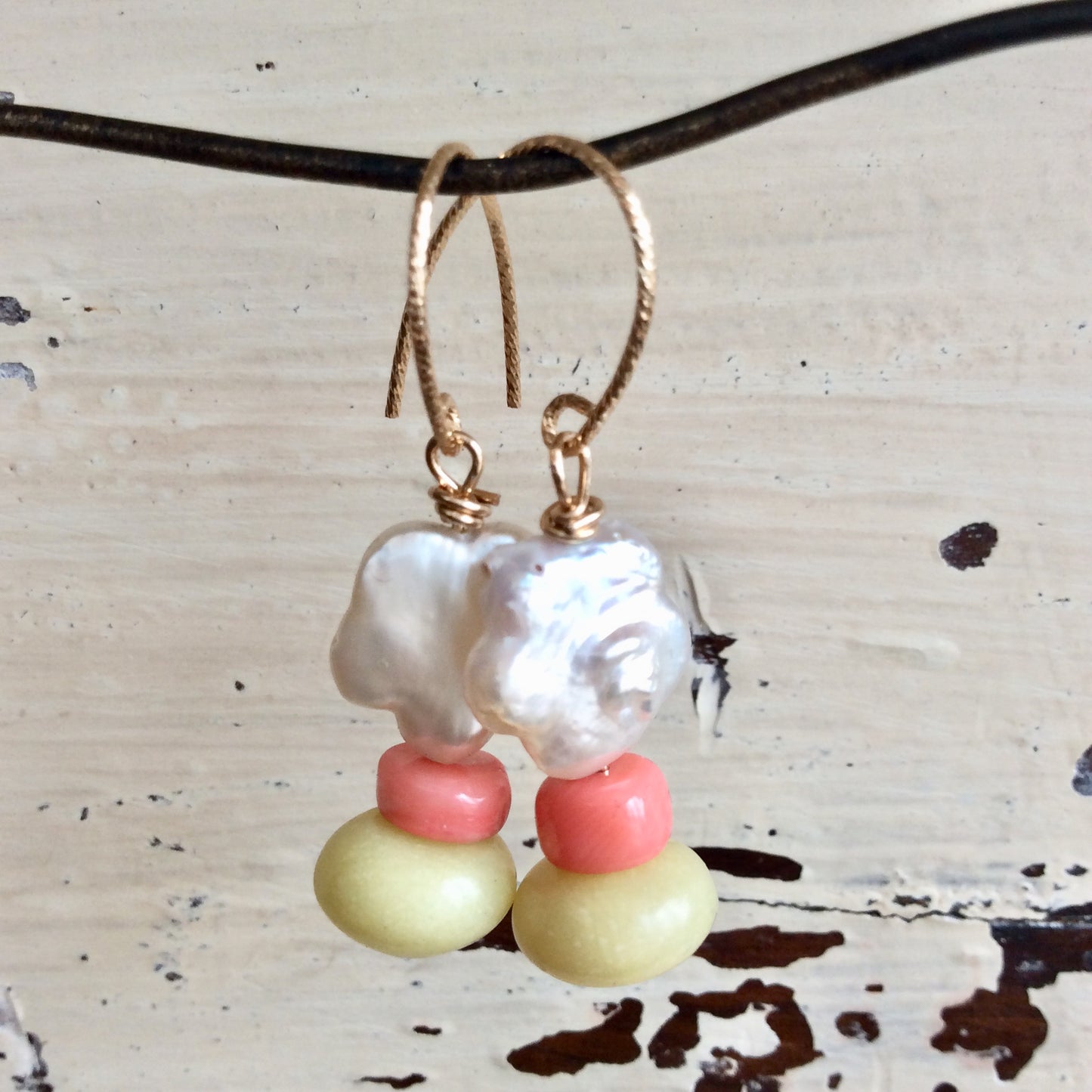 Dainty pearl drop earrings with baroque pearls, pink coral, and green quartz accents in floral design.