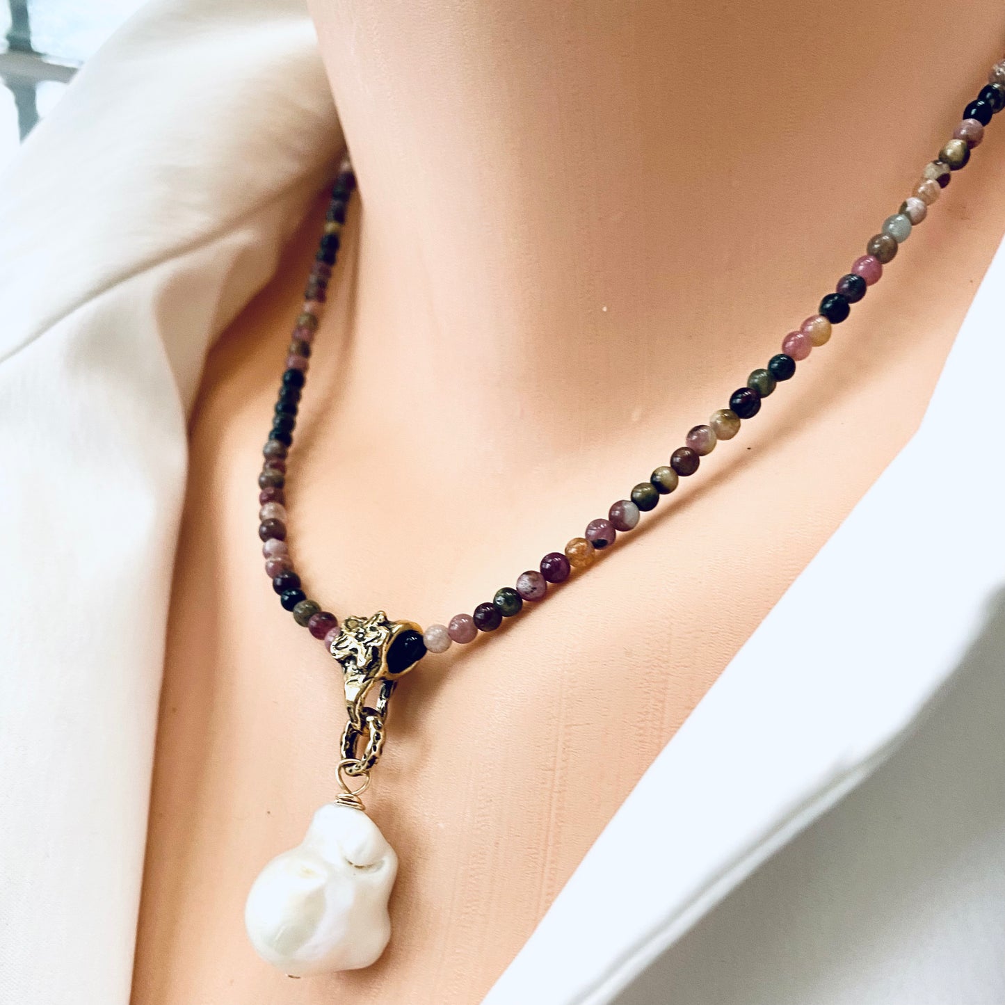 Tourmaline pearl necklace worn at the neckline with freshwater baroque pearl pendant