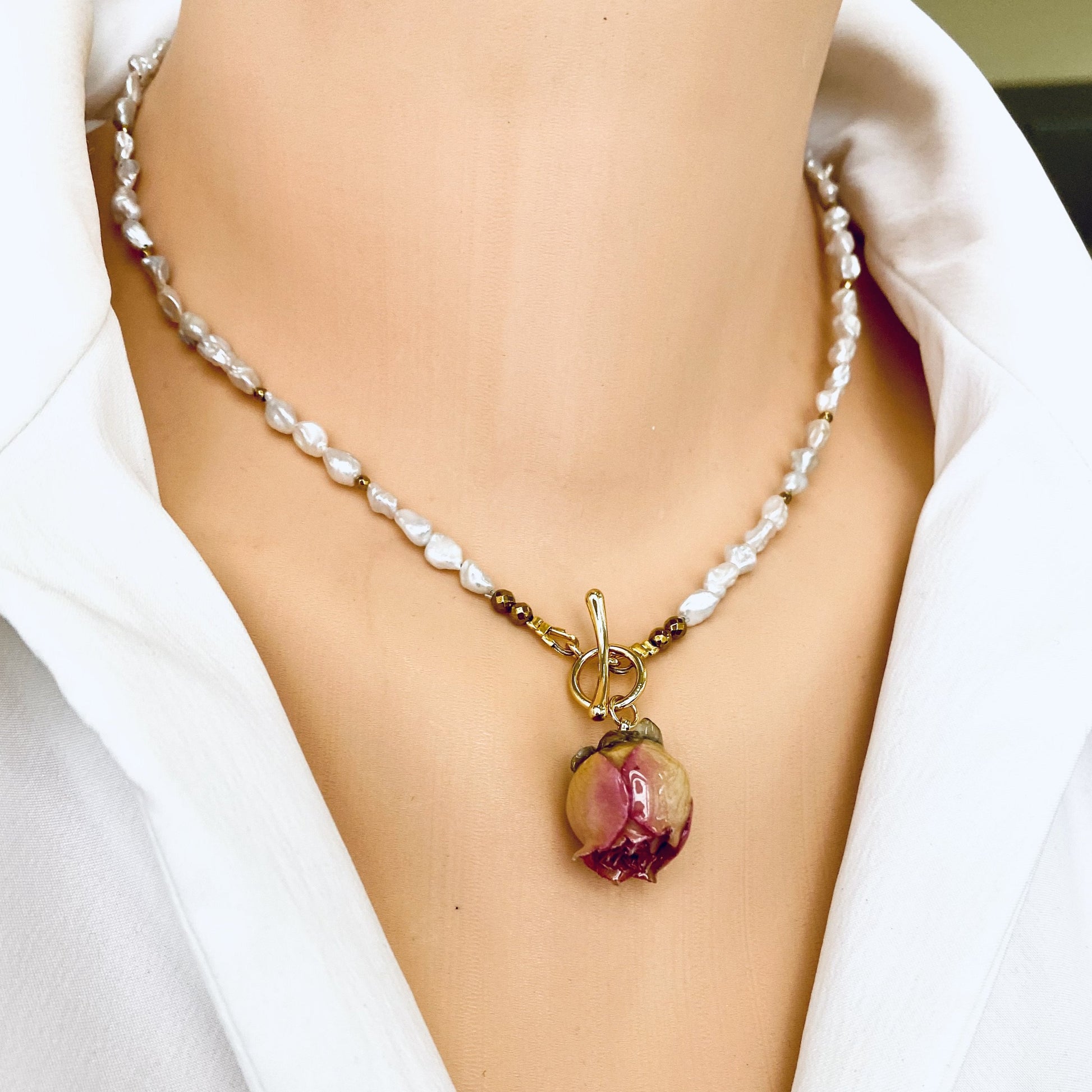 Real pink rosebud pearl necklace worn on model with natural freshwater pearls and gold accents