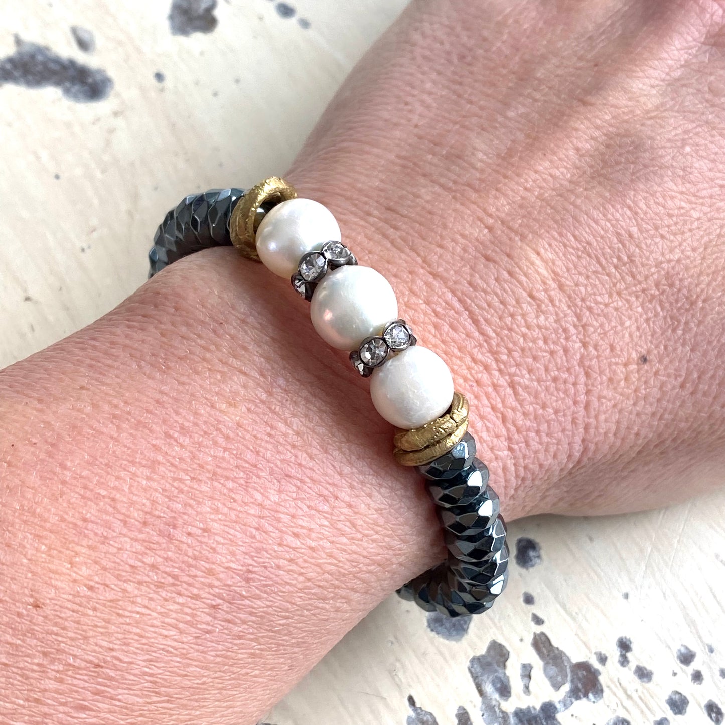 Freshwater pearl hematite stretch bracelet worn on wrist highlighting contrast of pearls and hematite