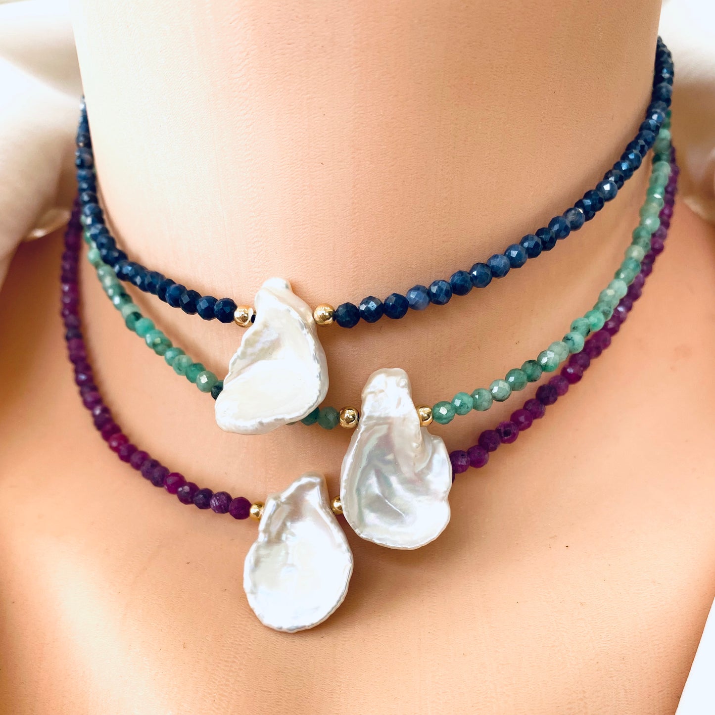 Emerald keshi pearl choker necklace layered with ruby and sapphire keshi pearl chokers
