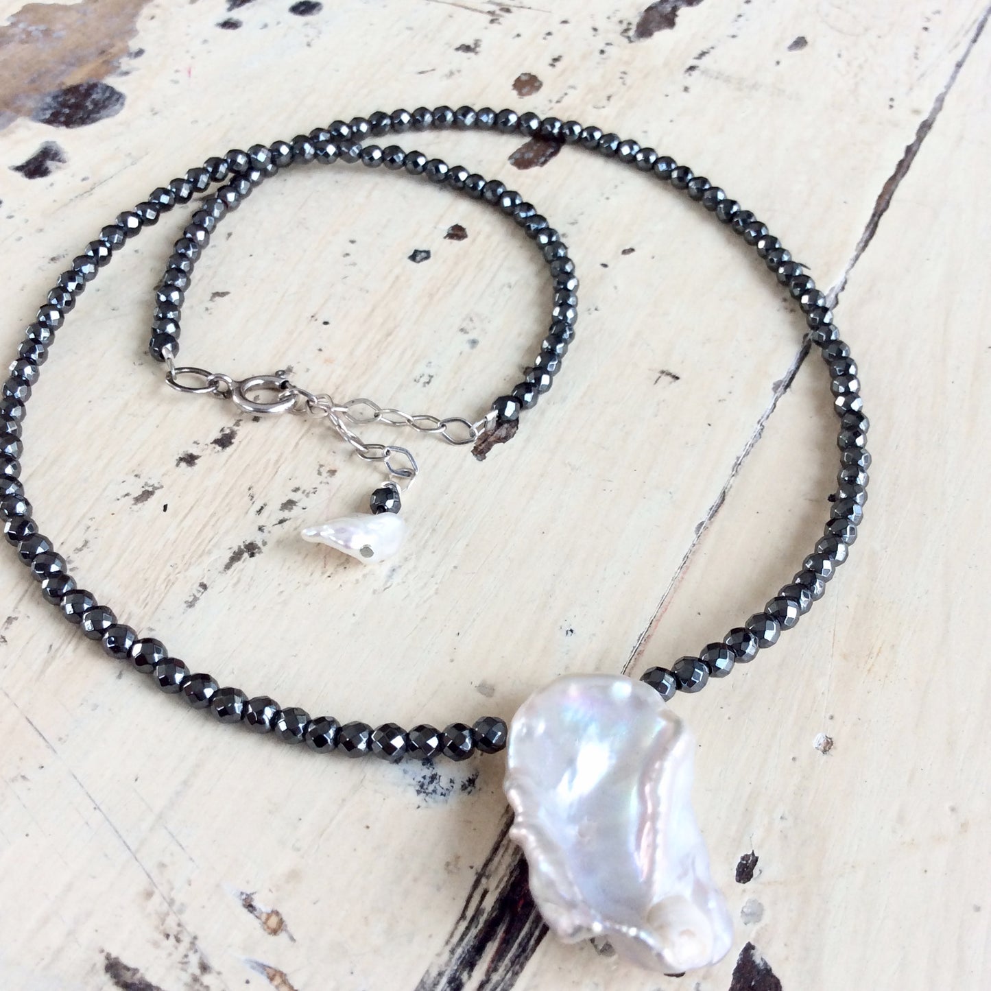 Hematite baroque pearl short necklace displayed flat showing charcoal hematite beads and pearl