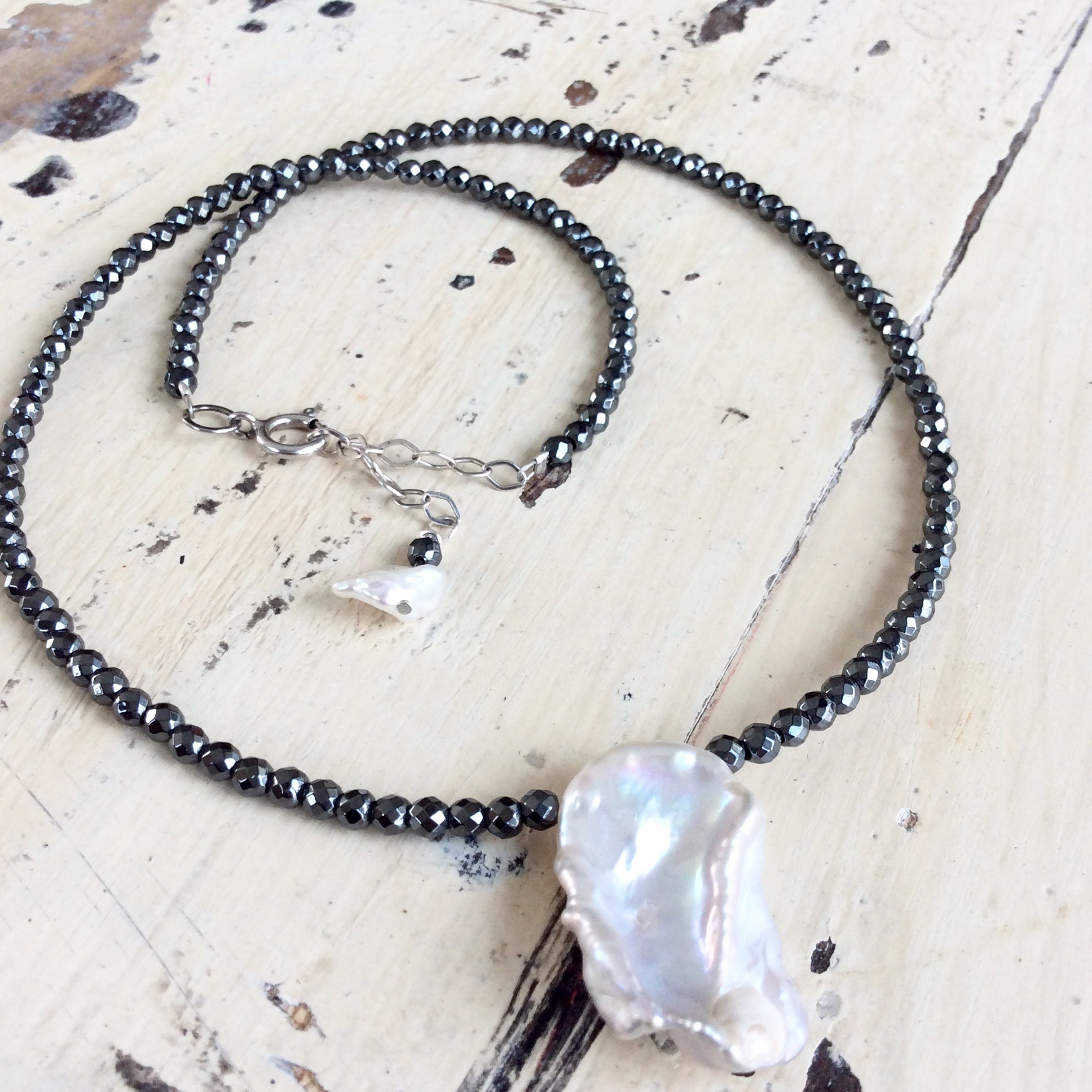 Hematite baroque pearl short necklace displayed flat showing charcoal hematite beads and pearl