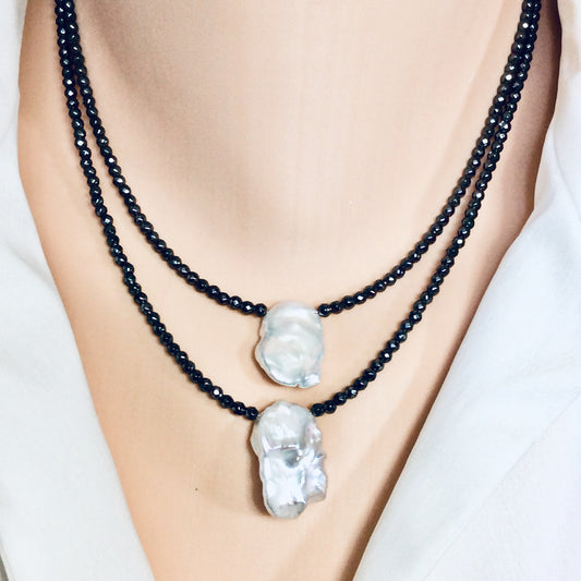Hematite baroque pearl short necklace worn on model layered with another necklace at the collarbone