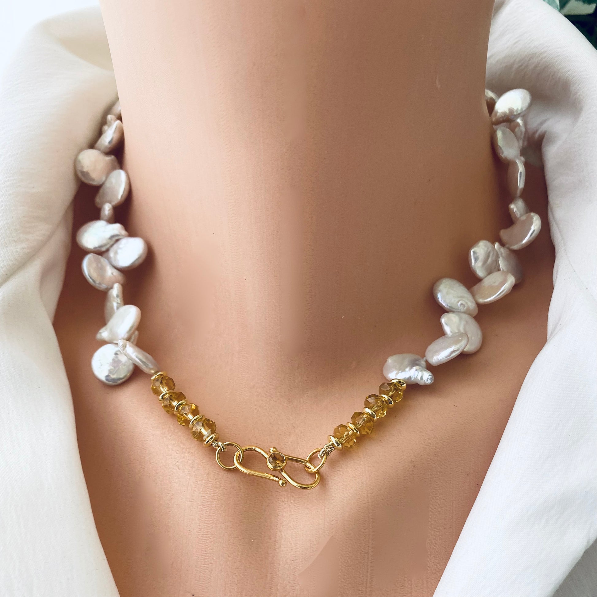Keshi pearl necklace featuring AAA-quality freshwater pearls and garnet beads, showcased on a mannequin.