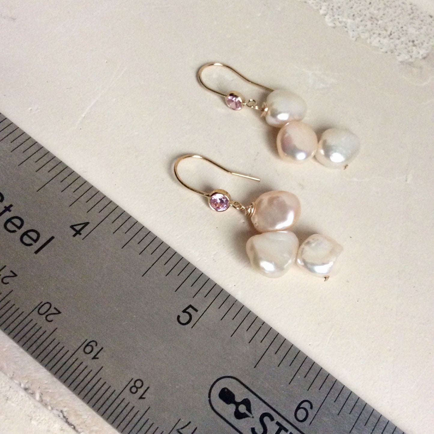 Elegant earrings composed of Natural Keshi pink and white pearls hanging from gold filled hooks with pink cubic zirconia bezel
