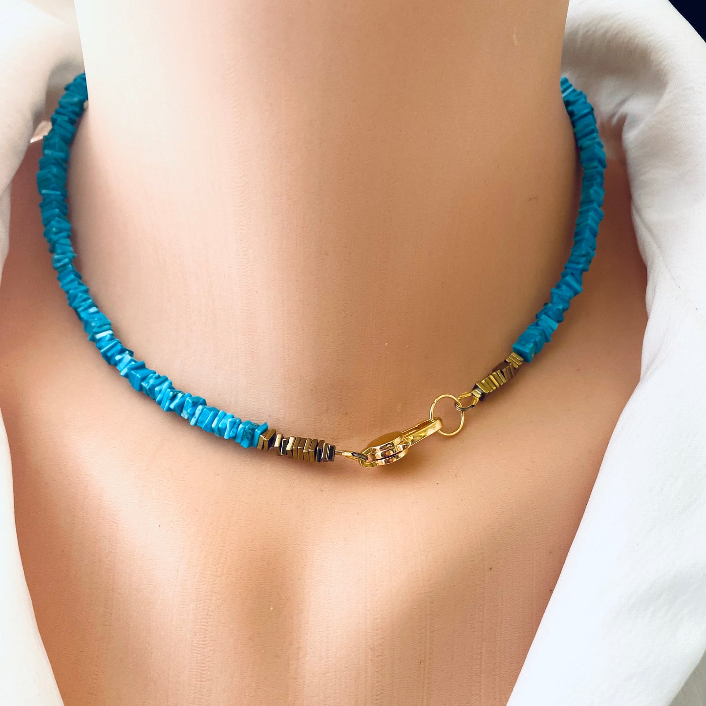 Turquoise choker necklace with natural turquoise beads and polished hematite accents, displayed on a mannequin.