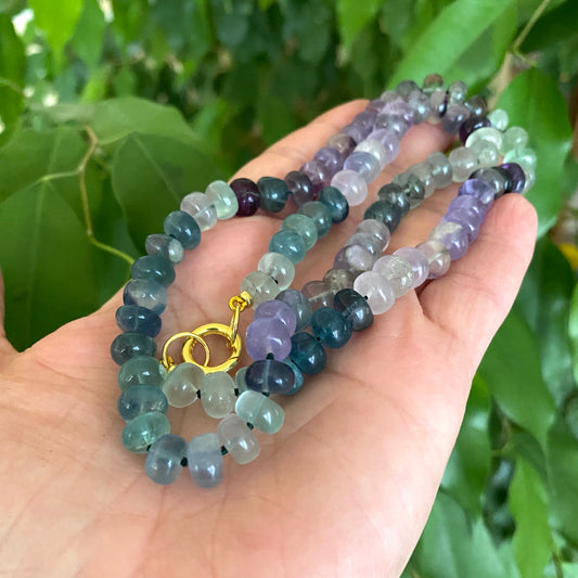 Fluorite candy necklace showcasing colorful rondelle beads in hand with gold clasp
