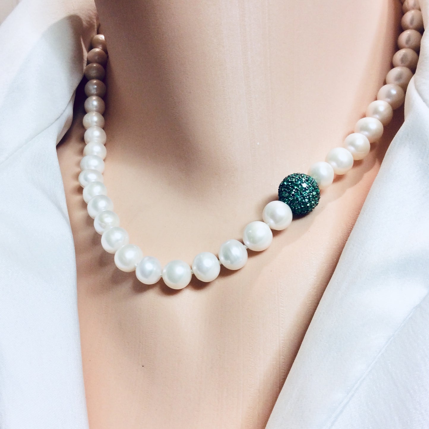 Pearl necklace with green CZ bead, handcrafted elegance featuring white freshwater pearls and vibrant emerald centerpiece.