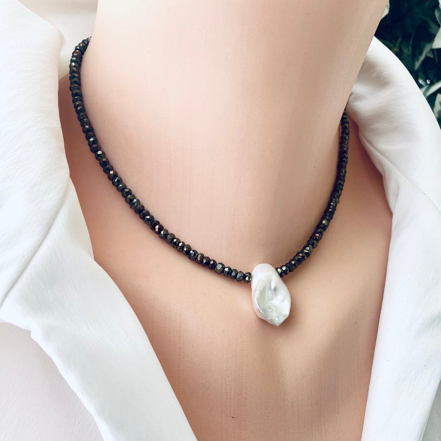 Pyrite pearl choker necklace with white keshi pearl on a model, showcasing organic elegance and modern design.