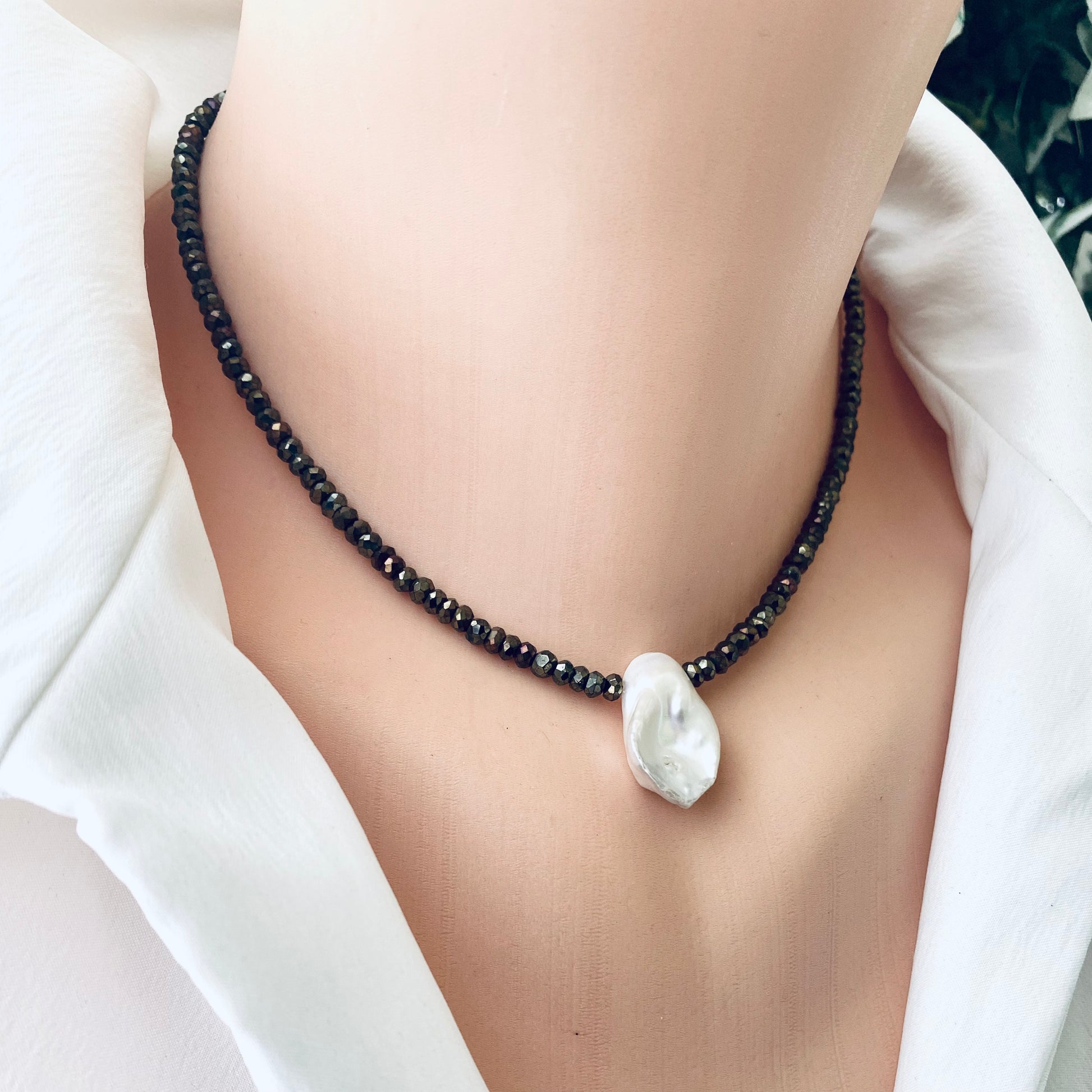 Pyrite pearl choker necklace with white keshi pearl on a model, showcasing organic elegance and modern design.