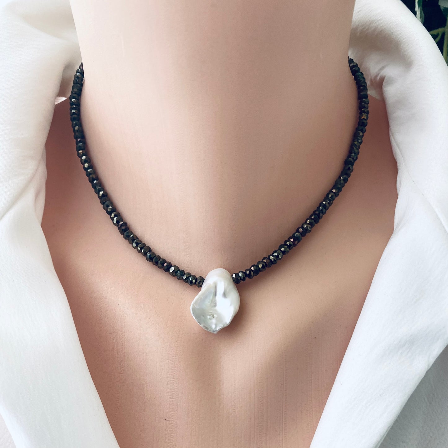 Pyrite pearl choker necklace with white keshi pearl displayed on a mannequin, highlighting its elegant design.