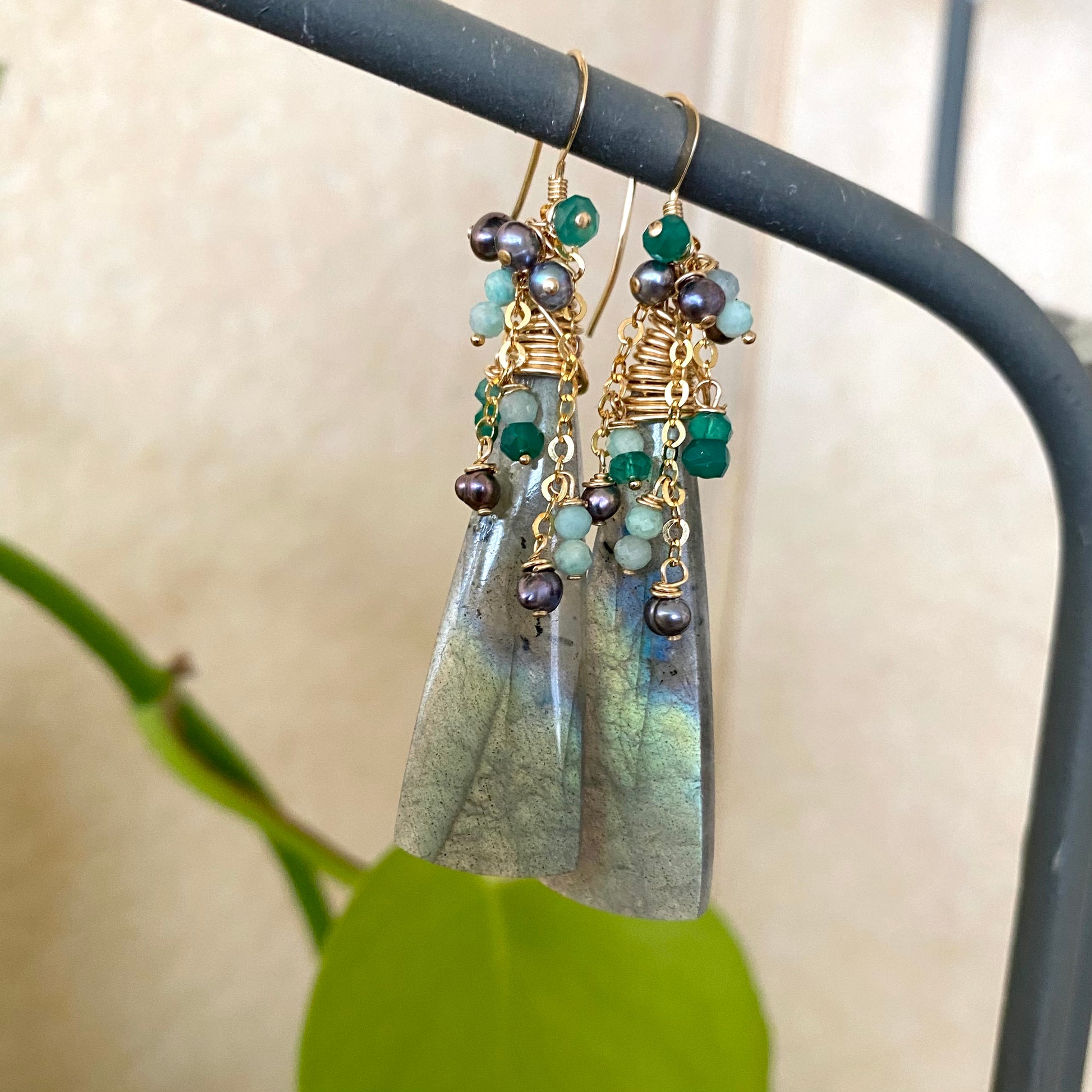 Labradorite amazonite green onyx black pearl earrings hanging on stand with gold filled details