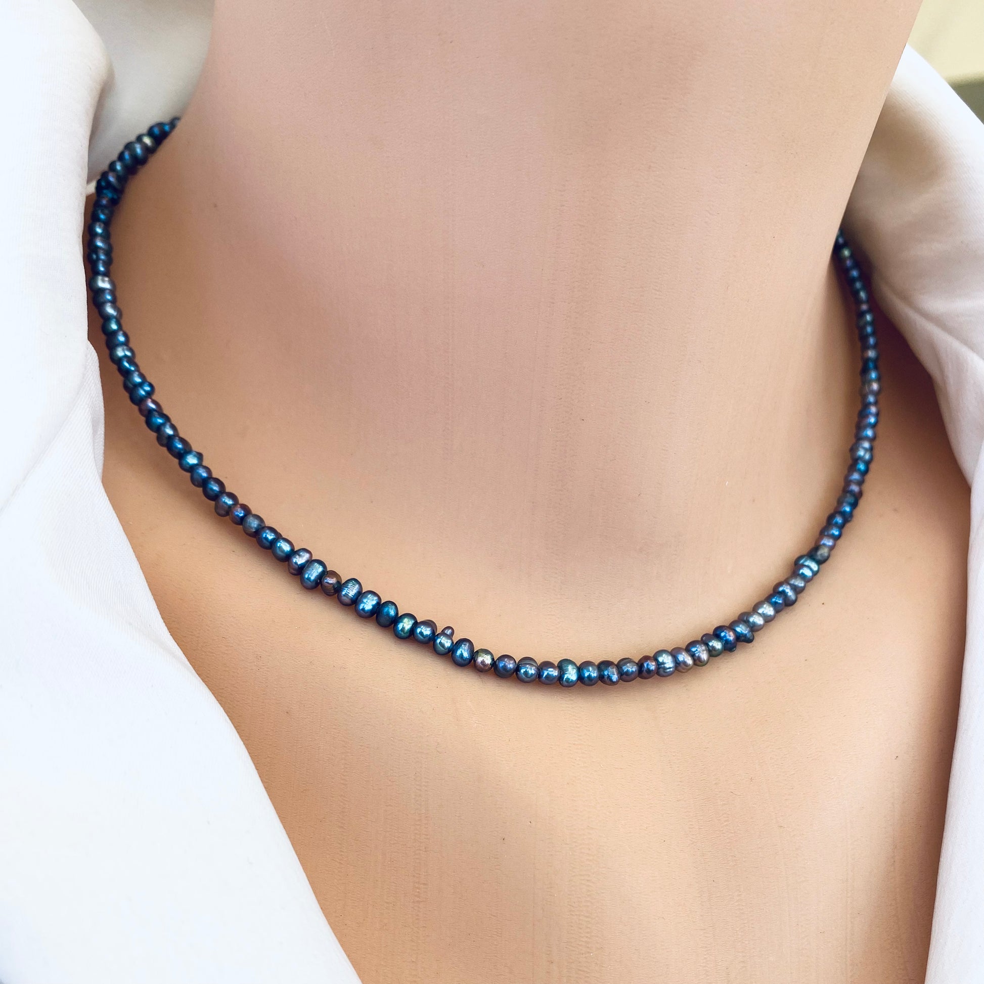 Black pearl hamsa necklace close-up on neck with minimalist pearl design, handcrafted in Canada