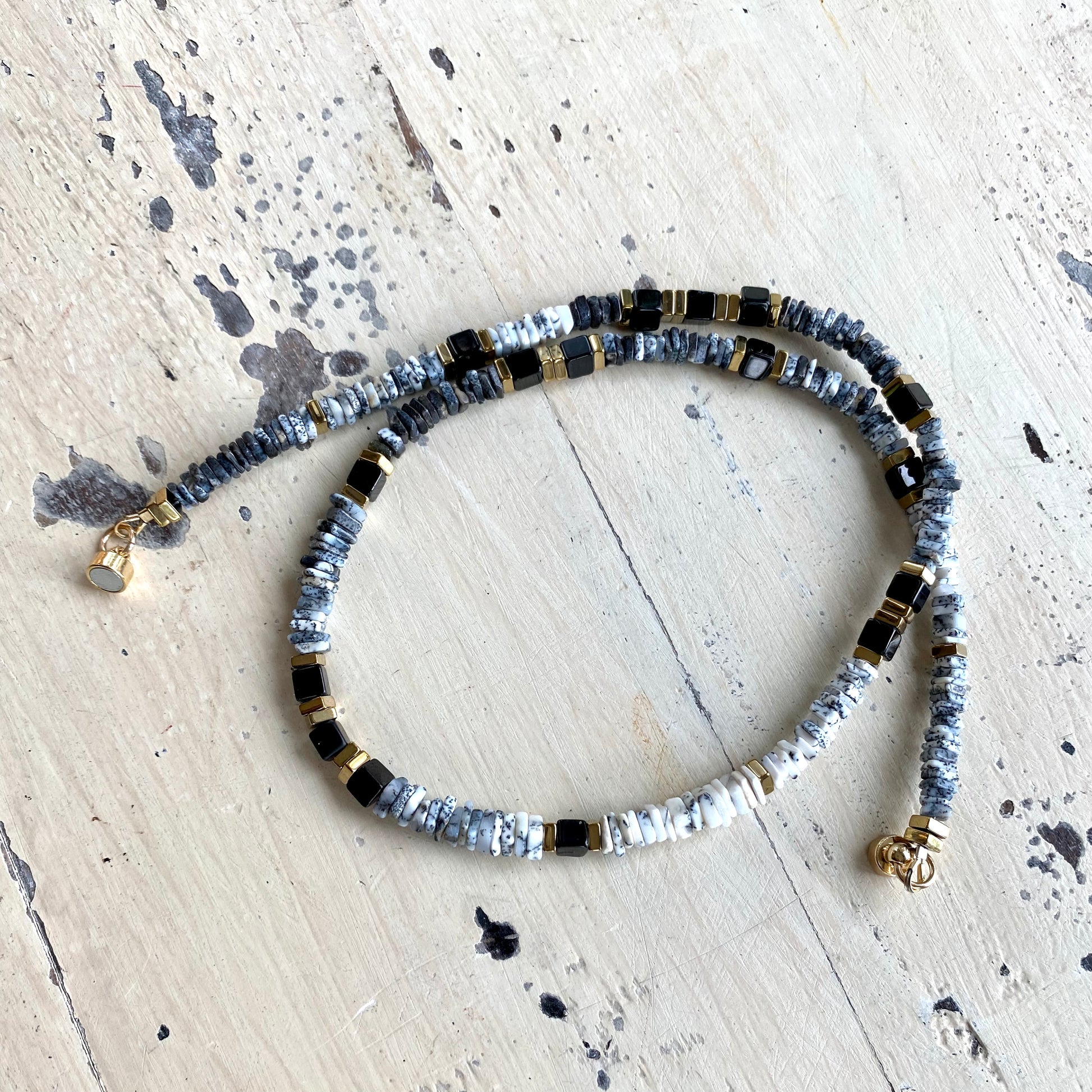 Dendritic opal necklace flat lay, square heishi opal beads with black spinel and gold hematite details