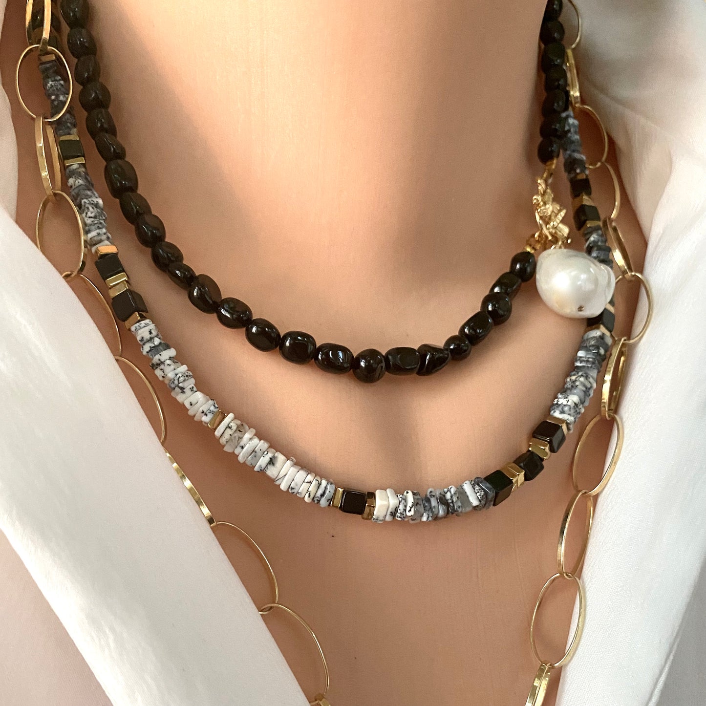 Dendritic opal necklace in hand, detailed view of opal heishi beads and magnetic clasp