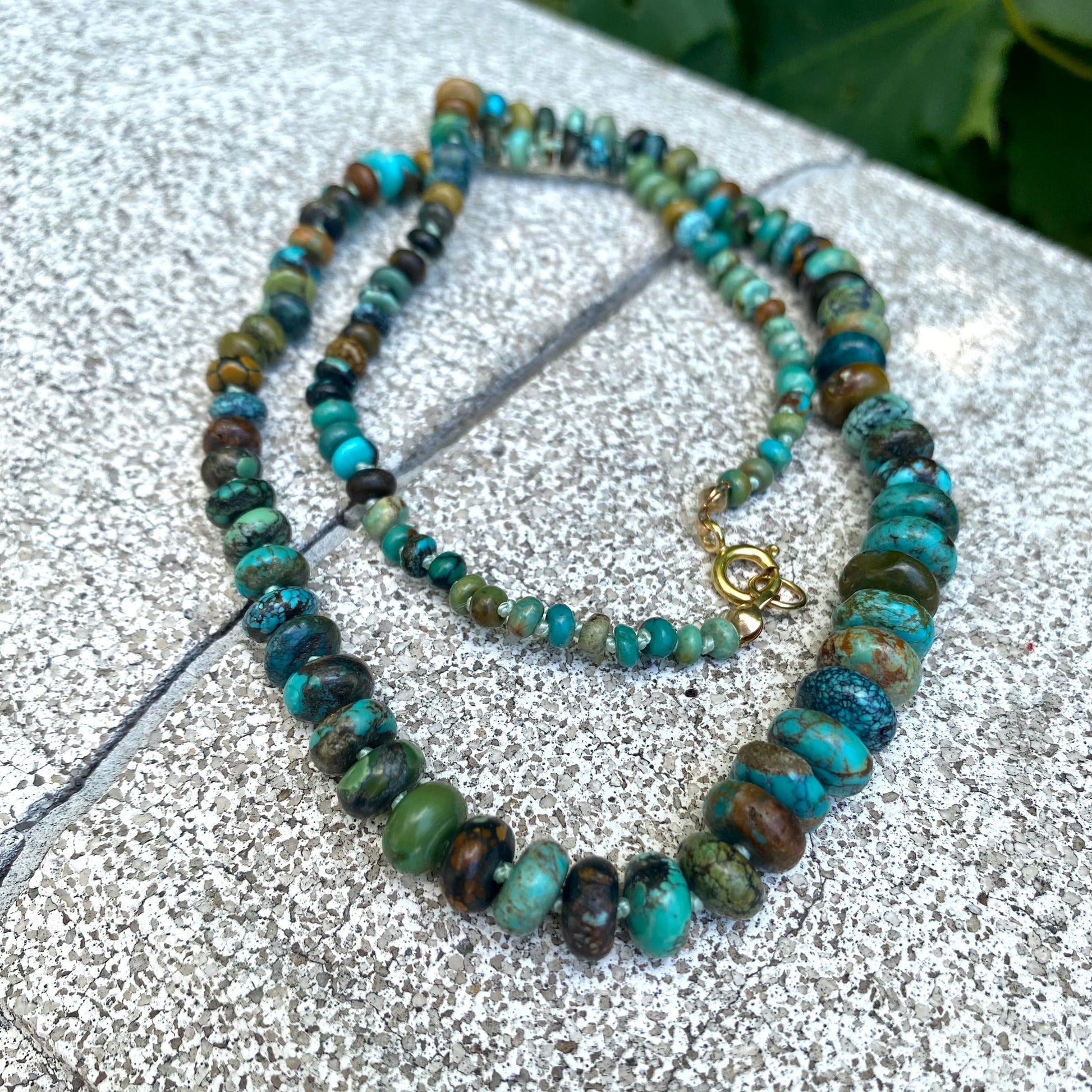 Turquoise necklace gold filled flat lay, hand-knotted graduated turquoise beads with gold filled closure