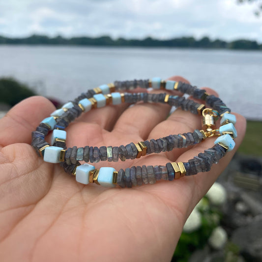 Labradorite and Blue Peru Opal Necklace in hand by the water, labradorite heishi and opal cube beads