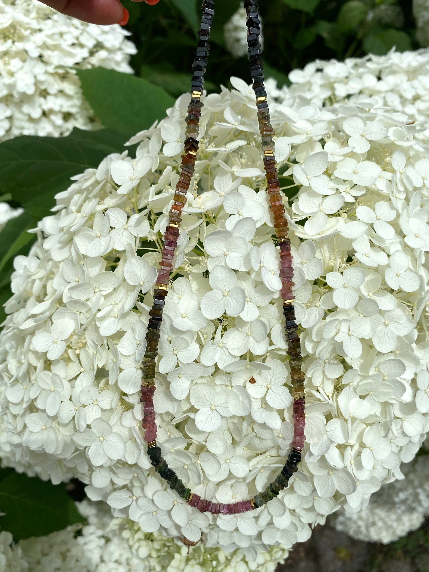 Tourmaline Necklace 14k Gold Filled laid on white flowers, delicate beaded necklace detail