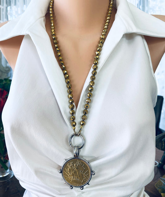 Mexican Peso Coin Pendant Necklace displayed on a mannequin, featuring a gold hematite beaded chain and bold statement design.