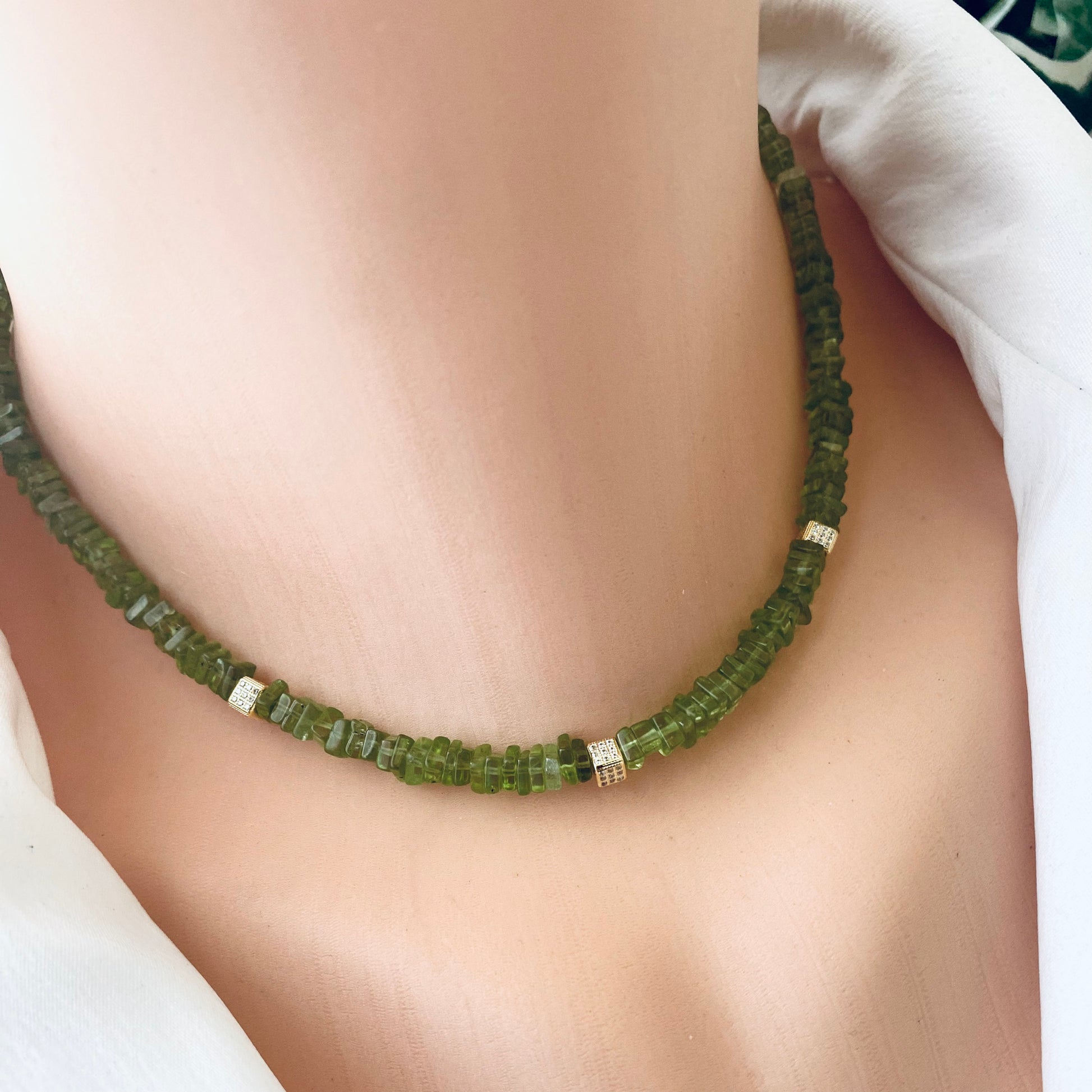 Peridot choker necklace featuring natural green peridot beads and sparkling accents, elegantly displayed on a mannequin.